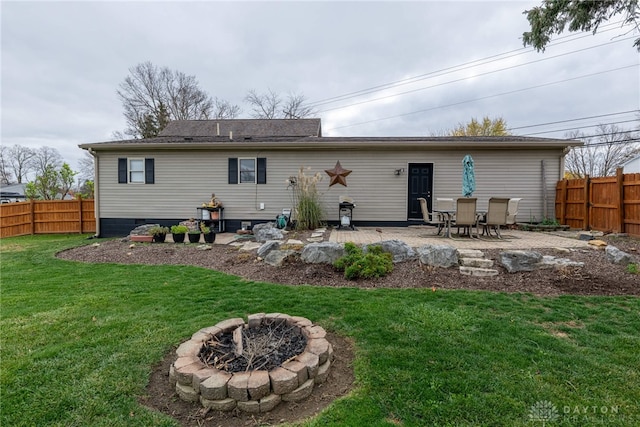 back of property featuring a patio area, a yard, and an outdoor fire pit