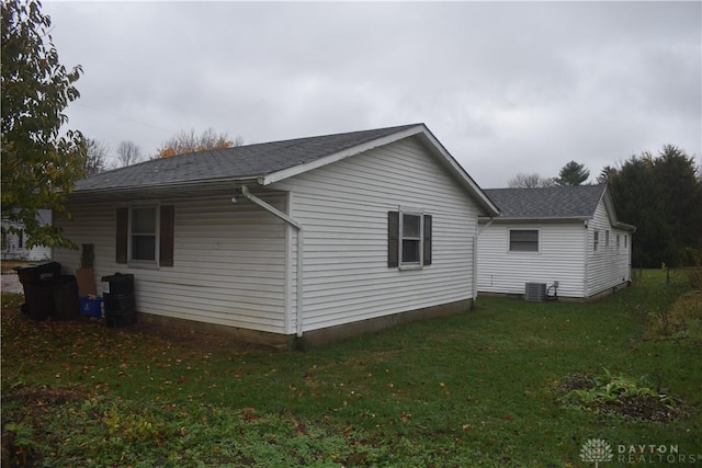 view of side of home with a yard and central AC unit