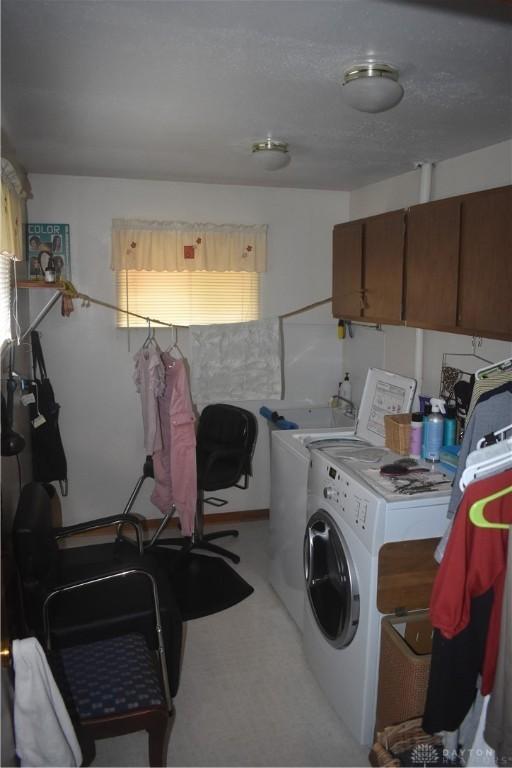 washroom featuring a textured ceiling and washer and clothes dryer