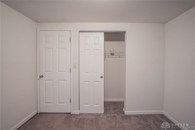 unfurnished bedroom featuring carpet flooring and a closet