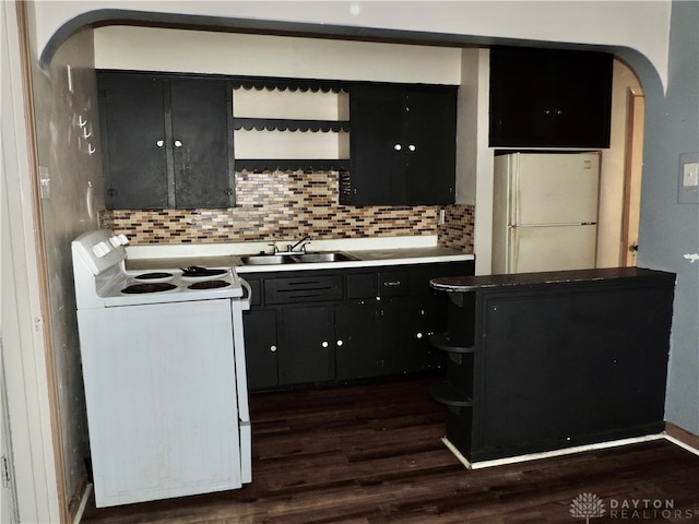 kitchen with backsplash, sink, dark hardwood / wood-style floors, and white appliances