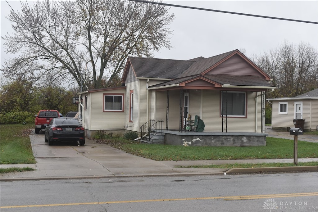 bungalow-style house featuring a porch and a front lawn