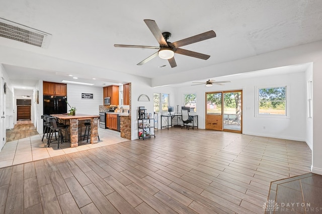 unfurnished living room featuring ceiling fan and light hardwood / wood-style flooring