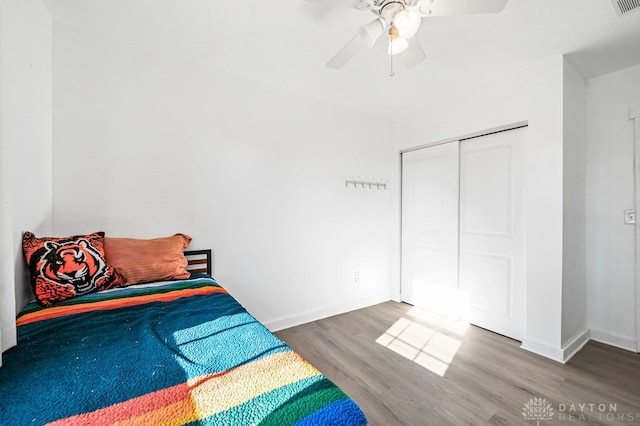 bedroom with ceiling fan, a closet, and wood-type flooring