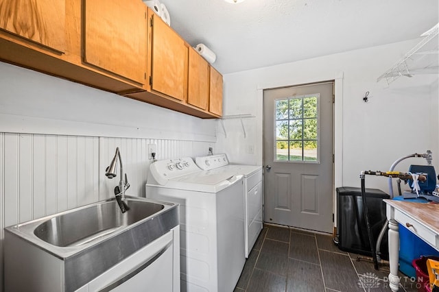 washroom with washer and dryer, cabinets, and sink