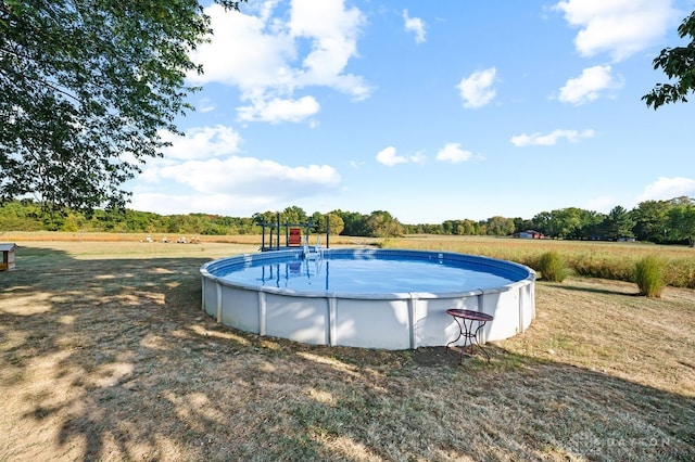 view of pool featuring a lawn