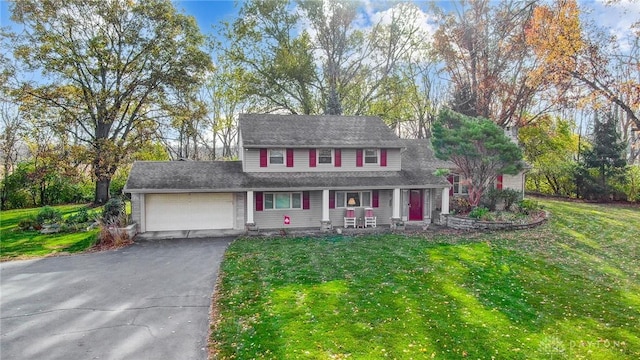 colonial house featuring a porch, a garage, and a front lawn