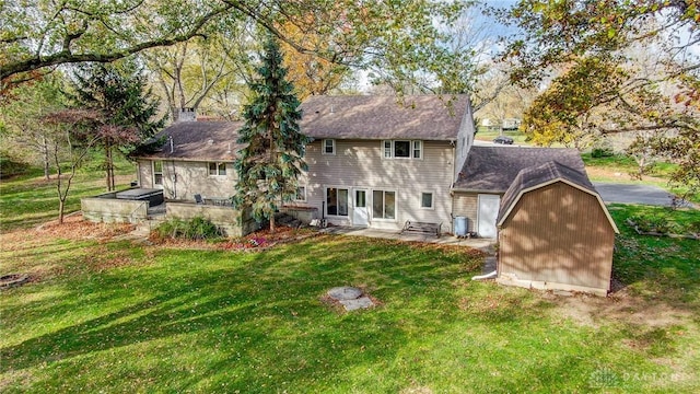 back of house featuring a lawn and a storage unit