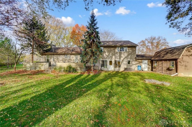 back of property featuring a yard and a storage unit