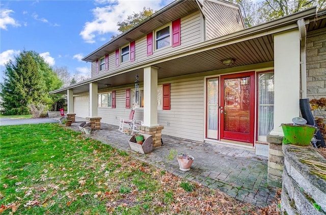 view of front facade with a front yard, a porch, and a garage