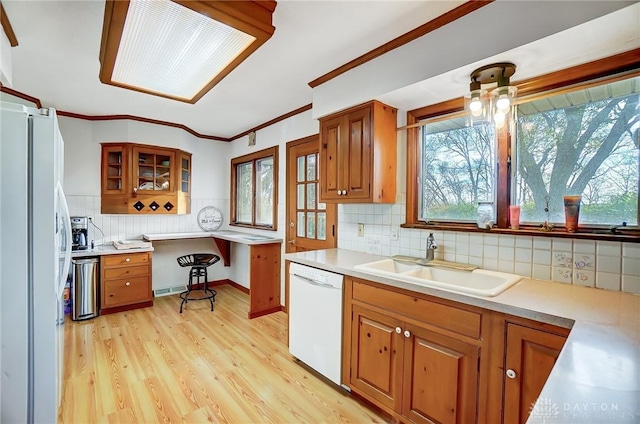 kitchen with white appliances, light hardwood / wood-style flooring, and a wealth of natural light