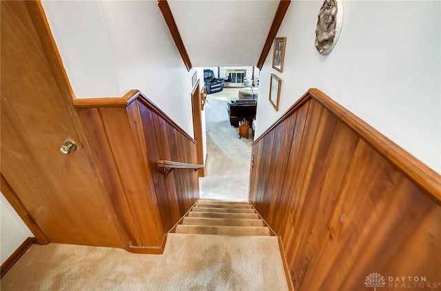 stairs featuring lofted ceiling with beams, carpet floors, and a fireplace