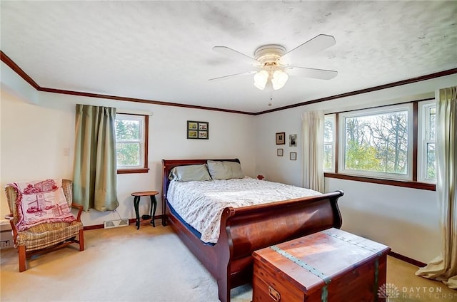 carpeted bedroom with multiple windows, ceiling fan, and crown molding