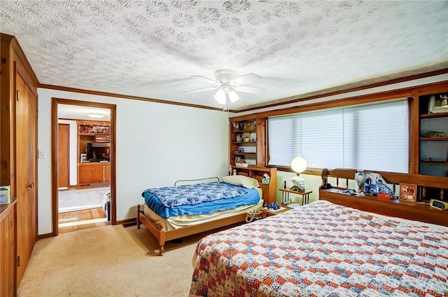 carpeted bedroom with ceiling fan, a textured ceiling, and ornamental molding