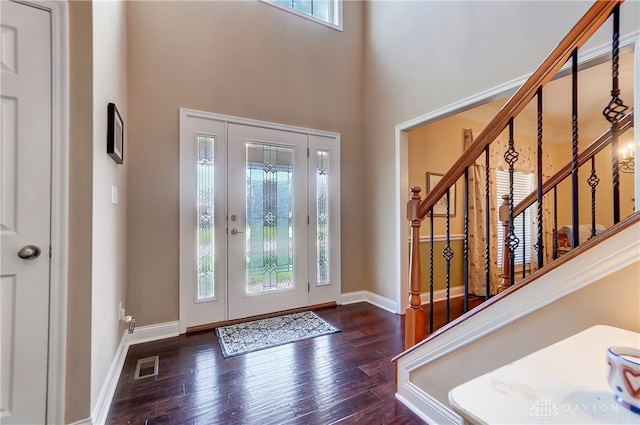 entrance foyer featuring plenty of natural light, a towering ceiling, and dark hardwood / wood-style floors