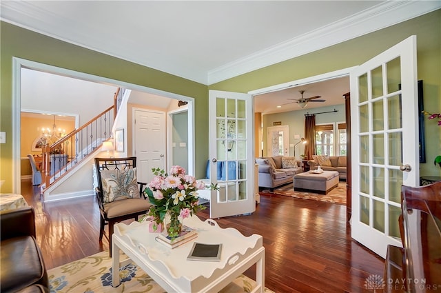 living room with french doors, ceiling fan with notable chandelier, dark hardwood / wood-style floors, and ornamental molding