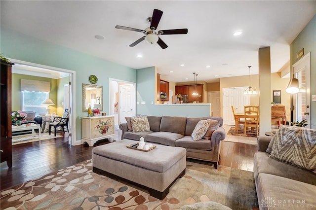 living room featuring hardwood / wood-style floors and ceiling fan with notable chandelier