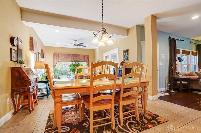 dining room with a wealth of natural light, light hardwood / wood-style floors, and ceiling fan with notable chandelier