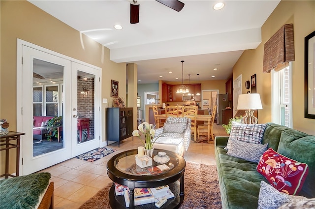 tiled living room with french doors and ceiling fan with notable chandelier