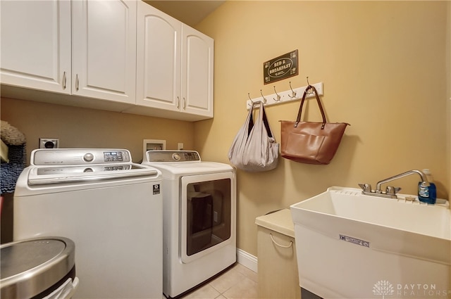 clothes washing area featuring cabinets, light tile patterned floors, separate washer and dryer, and sink