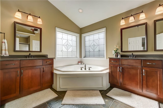 bathroom featuring a bathing tub, tile patterned flooring, vanity, and lofted ceiling