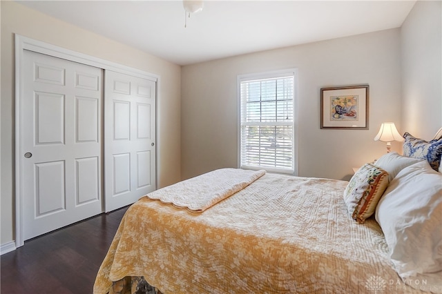 bedroom with dark hardwood / wood-style flooring, ceiling fan, and a closet