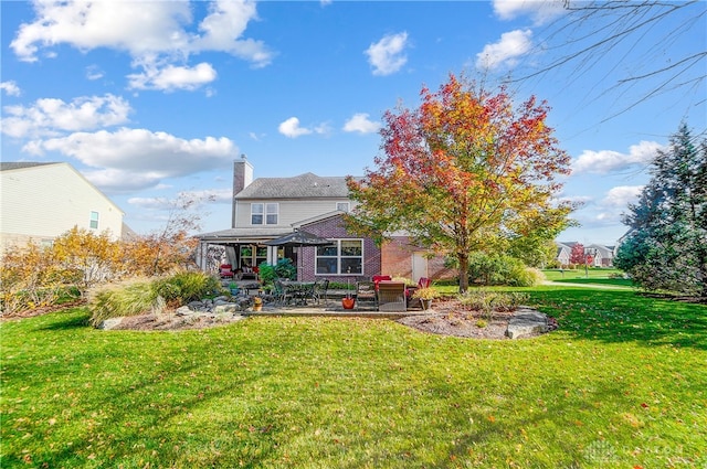 rear view of house featuring a yard and a patio