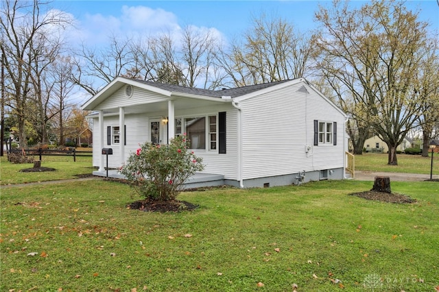 view of side of property featuring covered porch and a yard