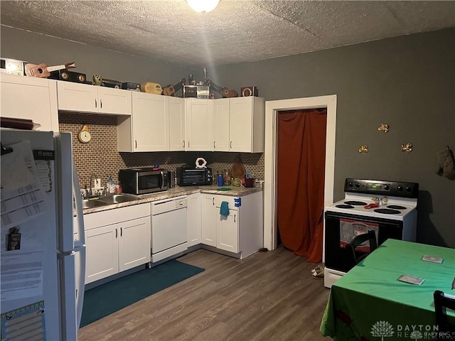 kitchen with white appliances, white cabinets, sink, decorative backsplash, and dark hardwood / wood-style flooring