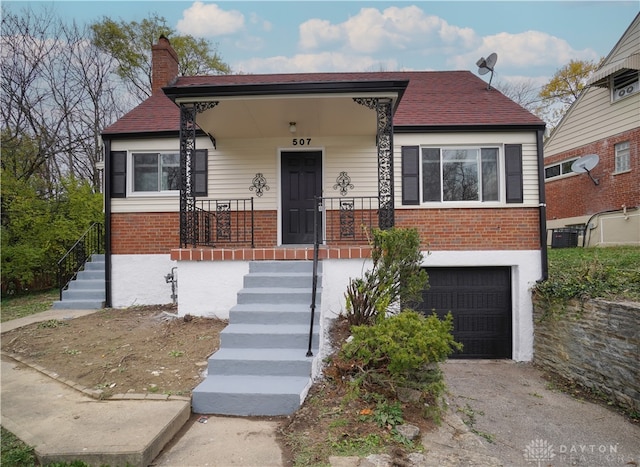 view of front facade featuring central AC, covered porch, and a garage