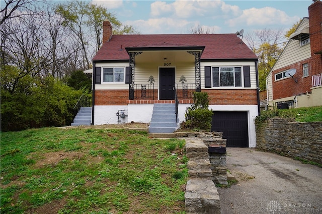 bungalow-style house with central air condition unit, a front lawn, covered porch, and a garage