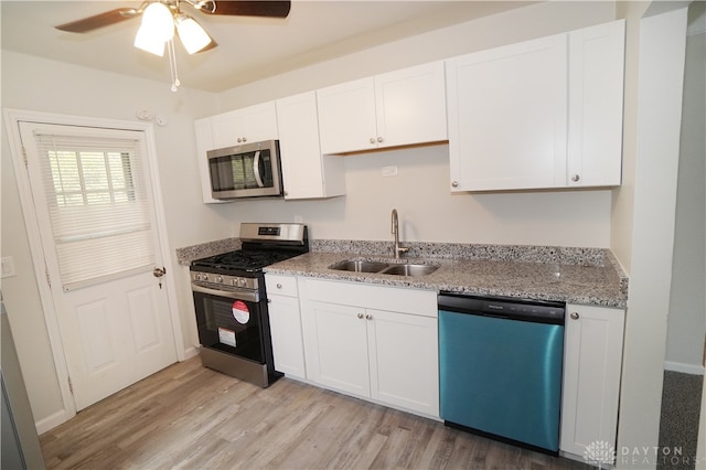 kitchen with ceiling fan, sink, stainless steel appliances, light hardwood / wood-style floors, and white cabinets