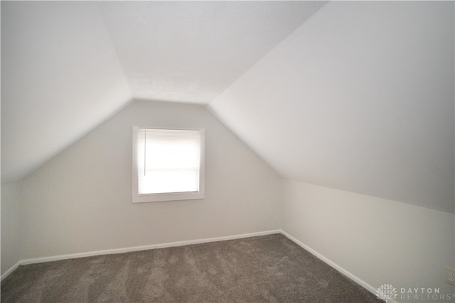 bonus room featuring dark carpet and lofted ceiling