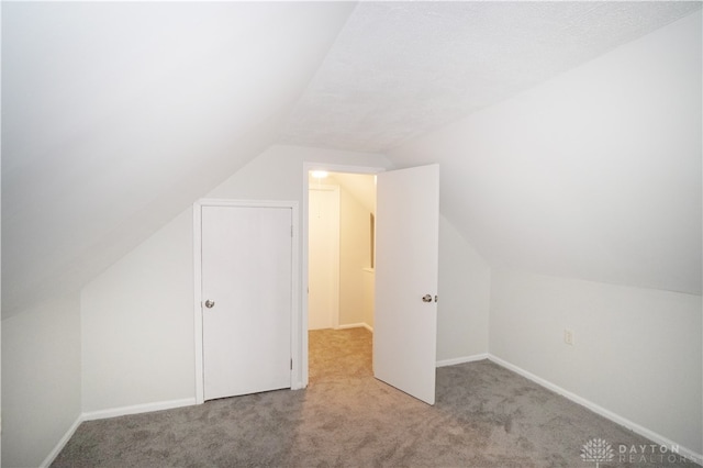 additional living space with light carpet and vaulted ceiling