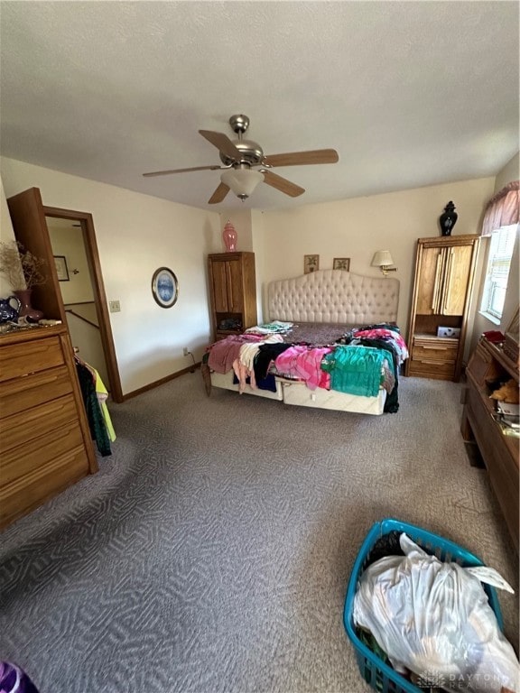 carpeted bedroom featuring ceiling fan and a textured ceiling