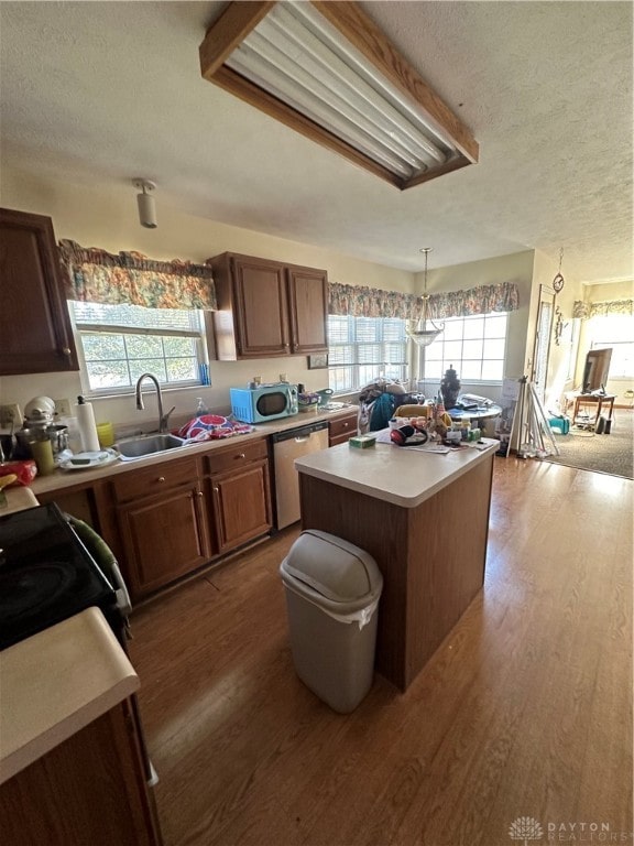 kitchen with a textured ceiling, dark hardwood / wood-style flooring, a kitchen island, and plenty of natural light