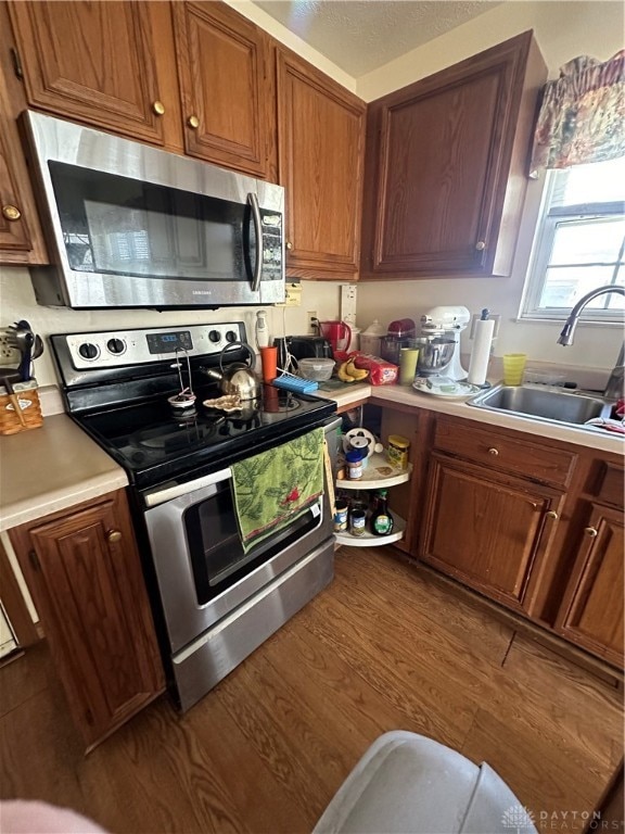 kitchen with hardwood / wood-style floors, sink, and stainless steel appliances