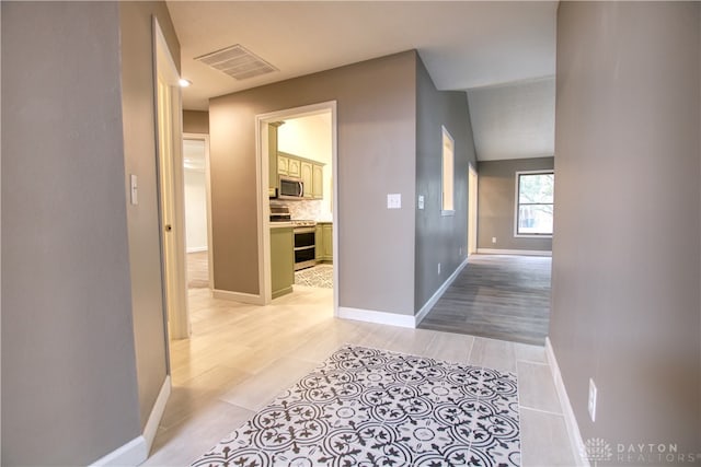 hallway with light hardwood / wood-style floors