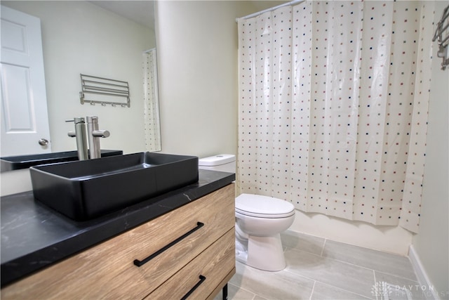 bathroom featuring toilet, vanity, a shower with shower curtain, and tile patterned floors