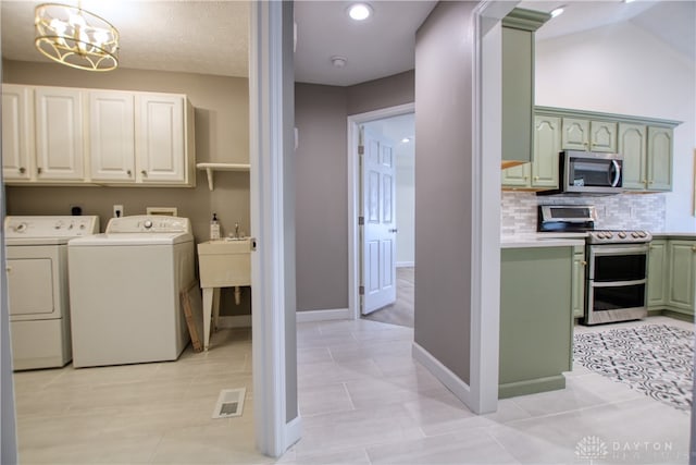 laundry room featuring cabinets, sink, a notable chandelier, washing machine and dryer, and light tile patterned flooring