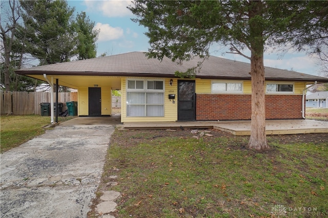 ranch-style house featuring a front yard and a carport