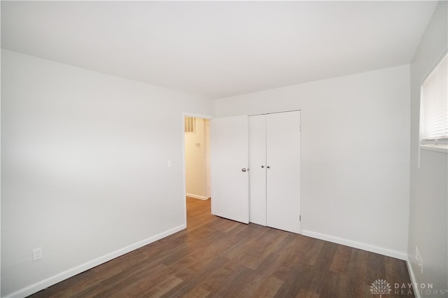 unfurnished bedroom with a closet and wood-type flooring