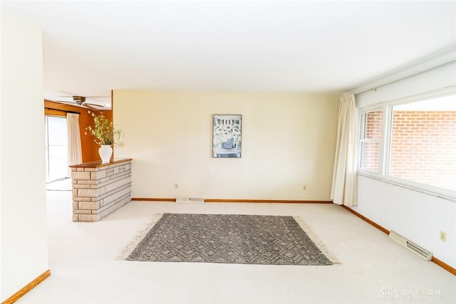 interior space with ceiling fan and light colored carpet