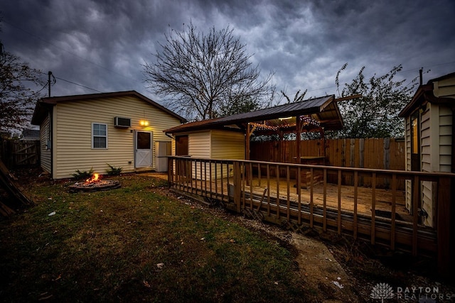 rear view of property with a fire pit and a deck