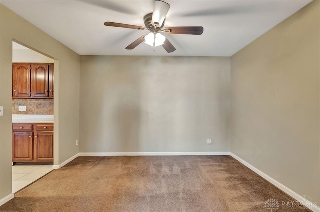 unfurnished room featuring ceiling fan and light colored carpet