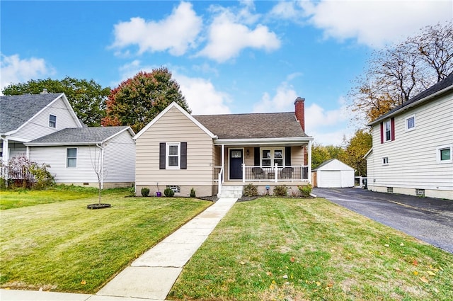 bungalow-style home with a porch, a garage, a front lawn, and an outdoor structure