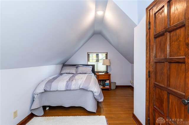 bedroom with dark hardwood / wood-style flooring and vaulted ceiling