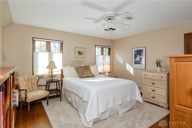 bedroom with hardwood / wood-style floors, ceiling fan, vaulted ceiling, and multiple windows