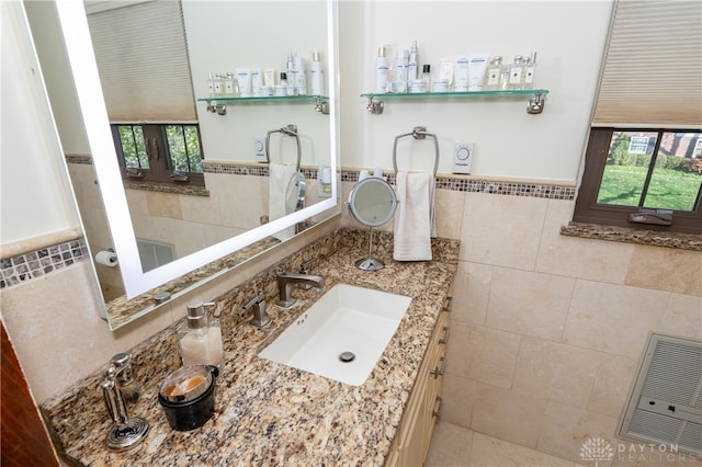 bathroom featuring vanity and tile walls