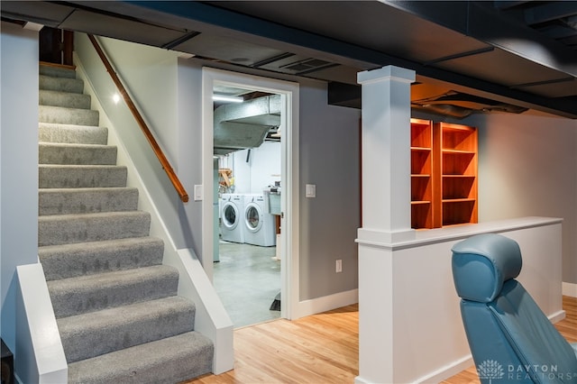 stairway featuring washing machine and dryer, hardwood / wood-style flooring, and ornate columns